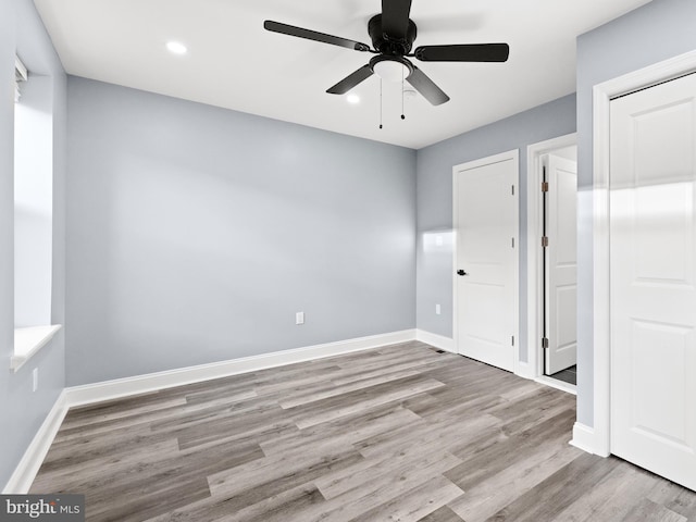 unfurnished bedroom with ceiling fan and light hardwood / wood-style flooring