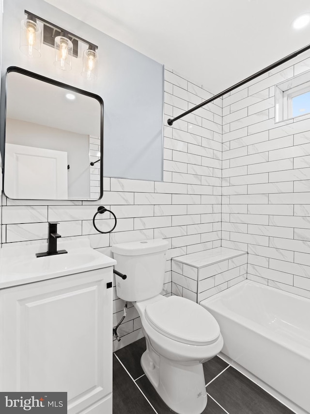 full bathroom with vanity, tile patterned floors, toilet, tile walls, and tiled shower / bath combo