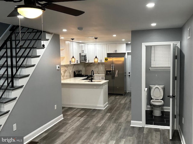 kitchen with white cabinetry, appliances with stainless steel finishes, tasteful backsplash, dark hardwood / wood-style floors, and decorative light fixtures