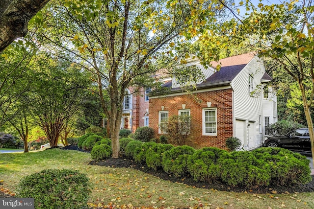 exterior space with a garage and a lawn