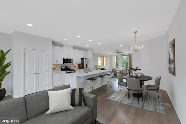 interior space with dark hardwood / wood-style floors and ceiling fan with notable chandelier