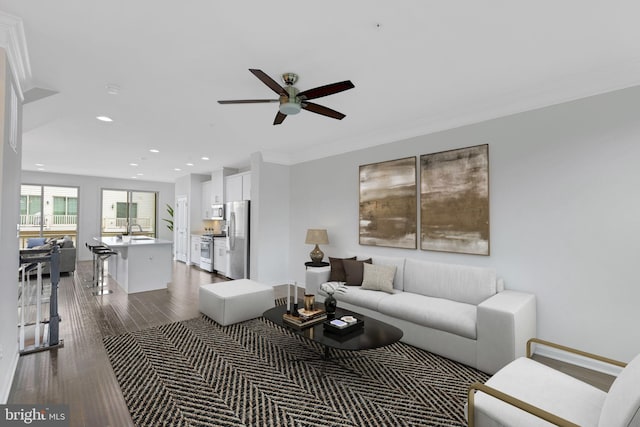 living room featuring crown molding, hardwood / wood-style flooring, and ceiling fan