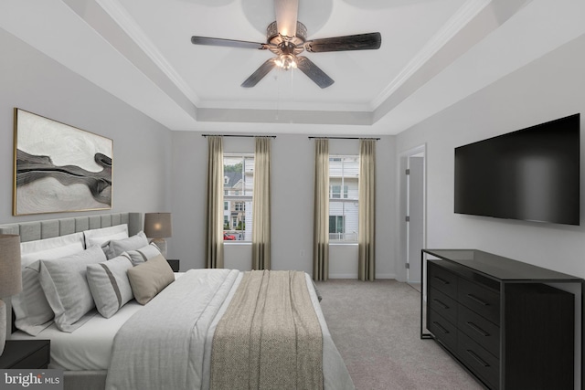 bedroom with light carpet, ornamental molding, a tray ceiling, and ceiling fan