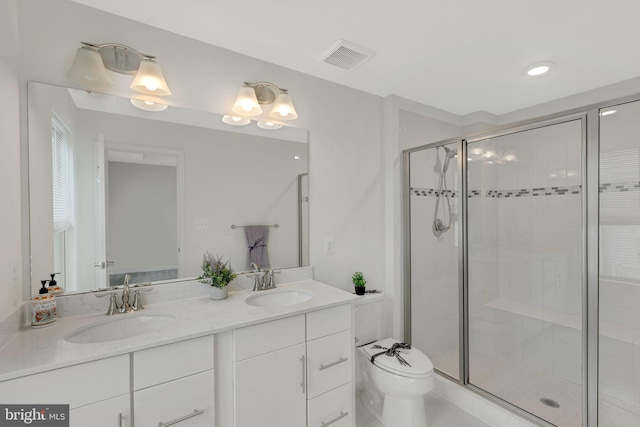 bathroom with vanity, a shower with shower door, and toilet