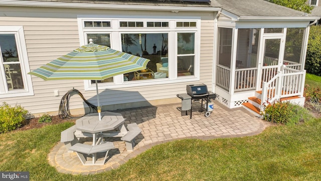 rear view of house featuring a sunroom, a patio area, and a yard