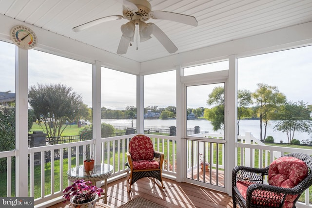 sunroom / solarium with a water view and ceiling fan