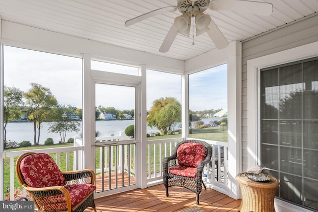 sunroom / solarium featuring a water view and ceiling fan