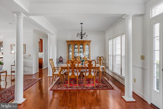 dining space with crown molding, hardwood / wood-style flooring, and a chandelier