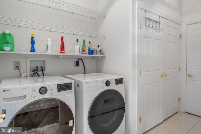 clothes washing area featuring washer and dryer and light tile patterned floors