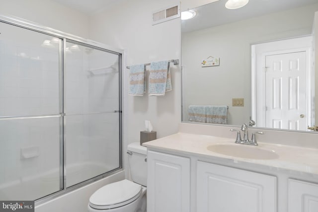 full bathroom with vanity, shower / bath combination with glass door, and toilet