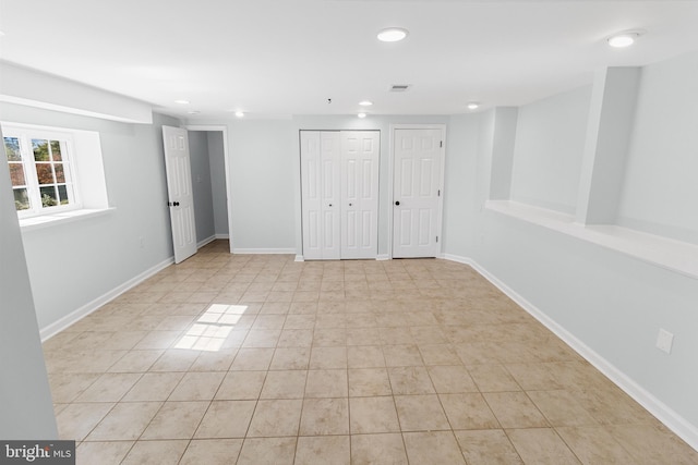 unfurnished bedroom featuring two closets and light tile patterned floors