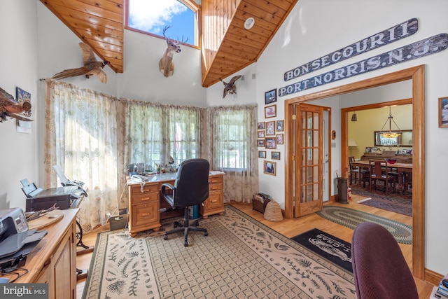 office space with a wealth of natural light, light hardwood / wood-style floors, wood ceiling, and high vaulted ceiling