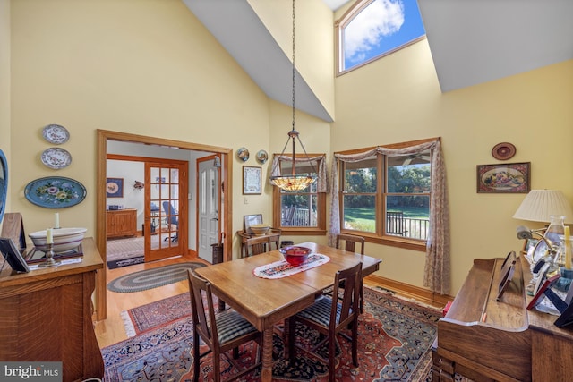 dining space featuring french doors, hardwood / wood-style flooring, and high vaulted ceiling