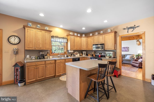 kitchen with a kitchen island, a breakfast bar area, stainless steel appliances, sink, and light wood-type flooring