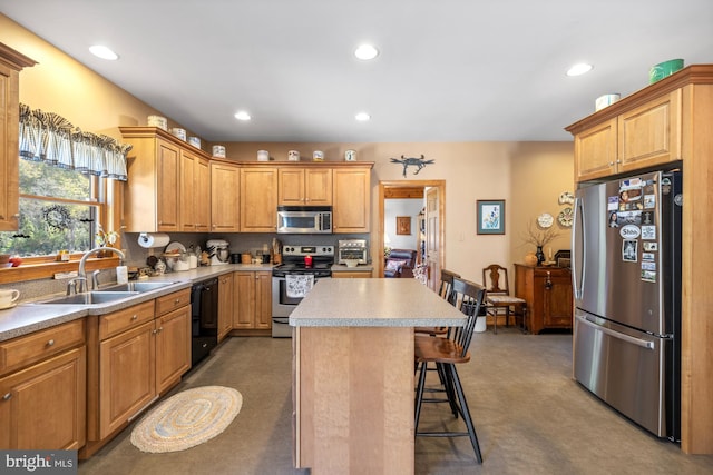 kitchen with a center island, stainless steel appliances, sink, and a breakfast bar area