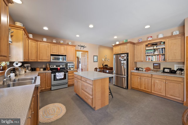 kitchen with sink, appliances with stainless steel finishes, a center island, and a breakfast bar area