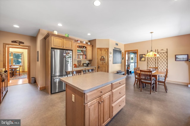 kitchen featuring a center island, decorative light fixtures, and stainless steel refrigerator