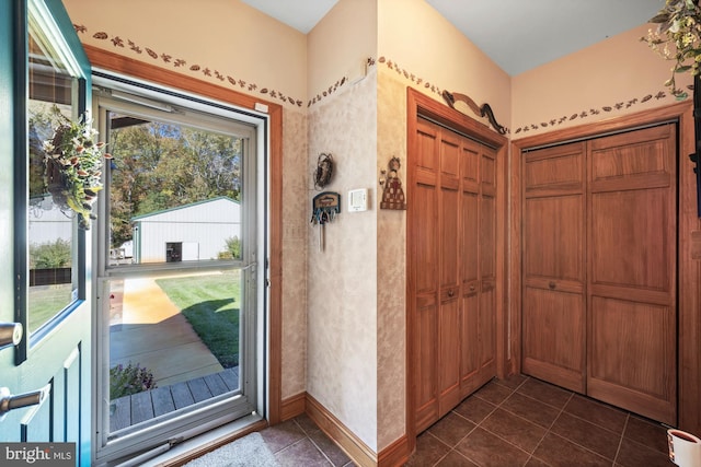 doorway to outside featuring dark tile patterned flooring