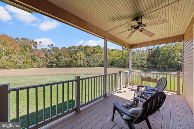 wooden deck with a yard and ceiling fan