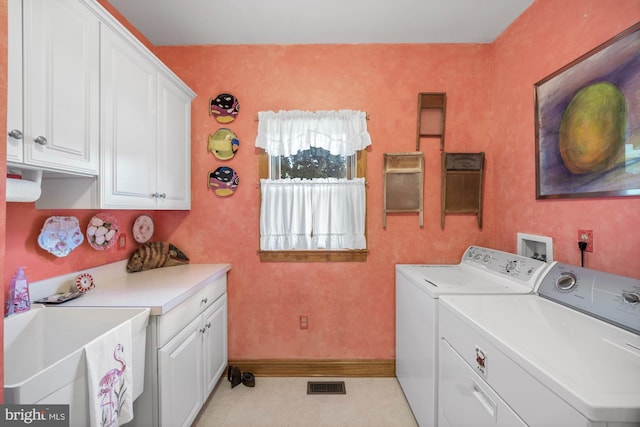 laundry room with light tile patterned floors, cabinets, and washer and clothes dryer