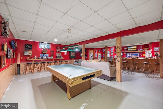 recreation room featuring a drop ceiling, indoor bar, concrete floors, and billiards