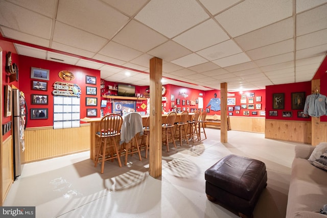 bar featuring a paneled ceiling and stainless steel refrigerator