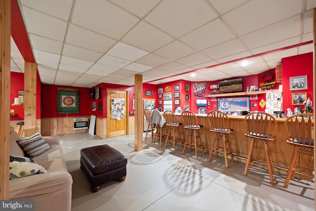 bar featuring a drop ceiling and heating unit