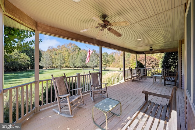 wooden terrace featuring a yard and ceiling fan