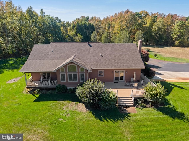 rear view of property with a wooden deck and a lawn