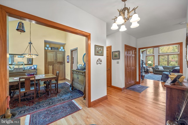 foyer with light hardwood / wood-style floors and a notable chandelier