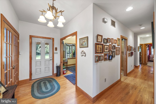 foyer featuring a chandelier and light wood-type flooring