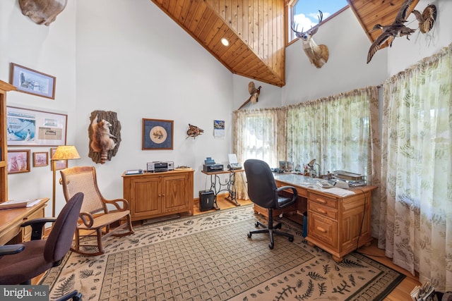 office space featuring wood ceiling, a high ceiling, and light wood-type flooring