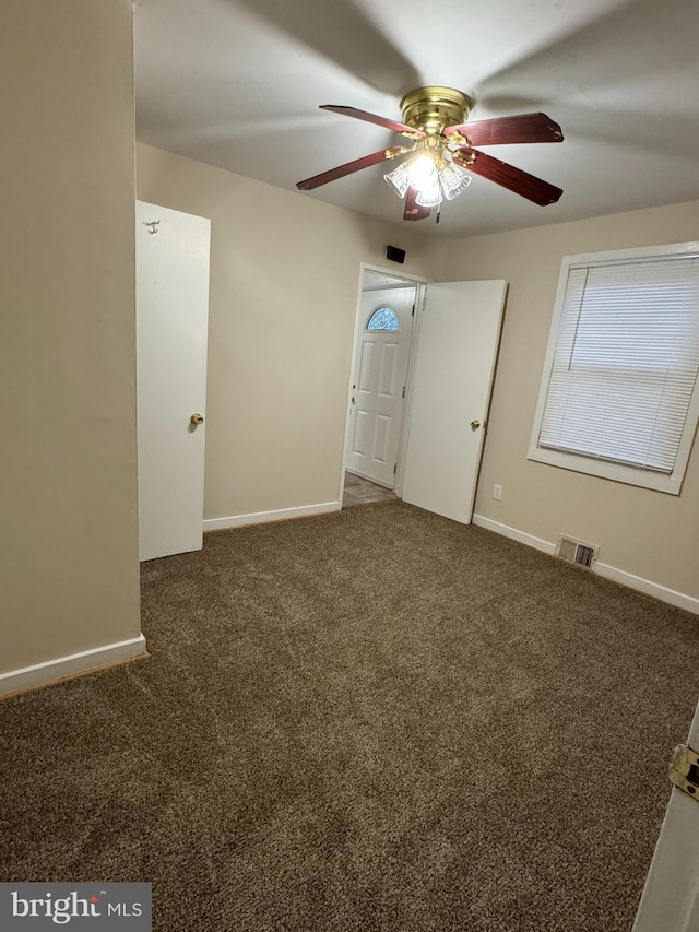 carpeted spare room with ceiling fan