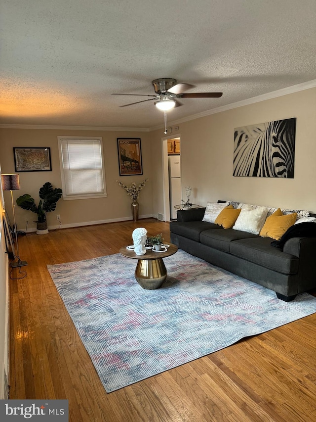 living room featuring ornamental molding, a textured ceiling, wood-type flooring, and ceiling fan