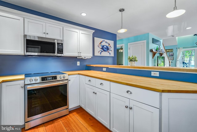 kitchen featuring pendant lighting, light hardwood / wood-style flooring, white cabinetry, stainless steel appliances, and wood counters