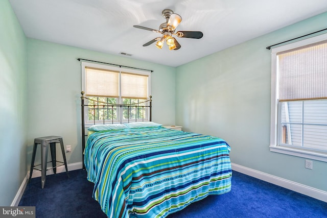 bedroom with ceiling fan and dark colored carpet