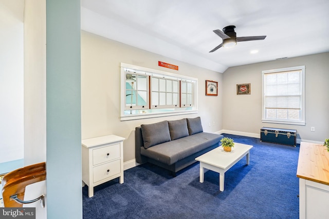 carpeted living room with ceiling fan and vaulted ceiling