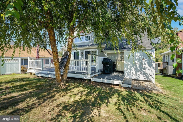 back of house featuring central AC unit, a deck, and a yard