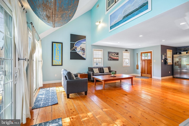 living room featuring high vaulted ceiling and hardwood / wood-style floors