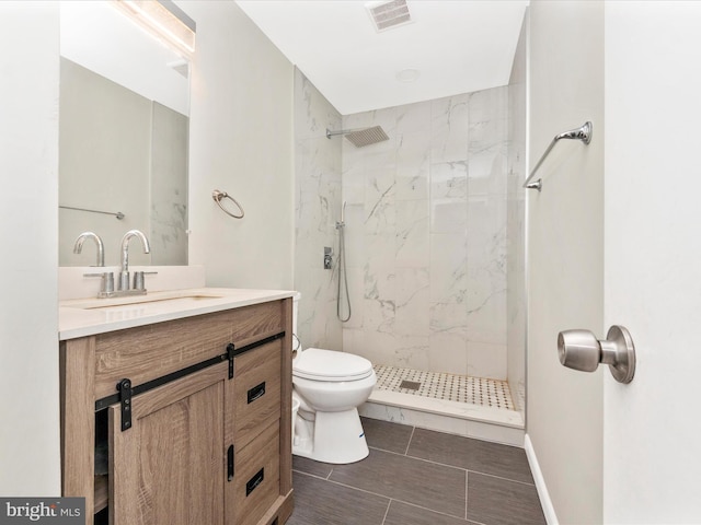 bathroom featuring tiled shower, vanity, and toilet