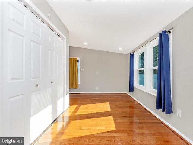 unfurnished room with hardwood / wood-style flooring and vaulted ceiling