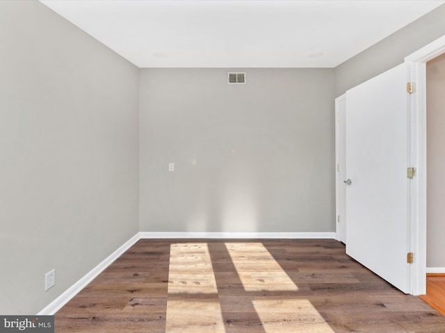 unfurnished room featuring dark wood-type flooring