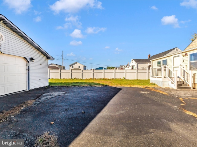 view of yard featuring a garage and a wooden deck