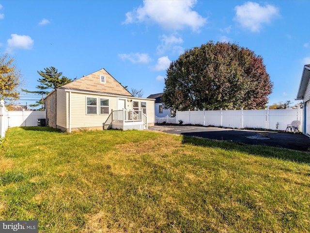 back of house featuring a yard and central AC unit