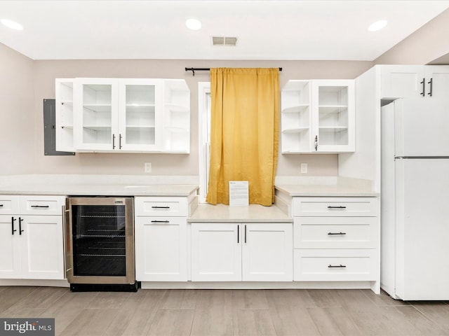 kitchen featuring white fridge, white cabinetry, beverage cooler, and light hardwood / wood-style flooring