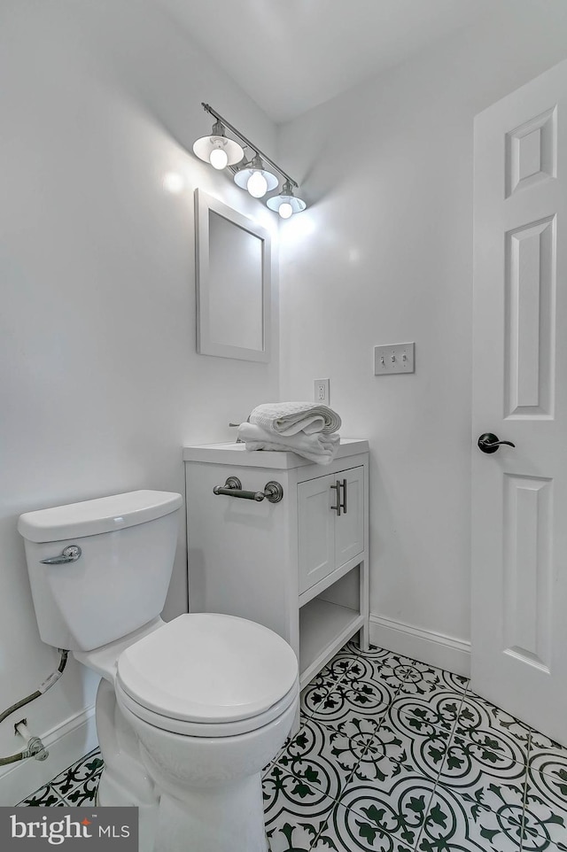 bathroom with tile patterned flooring, vanity, and toilet