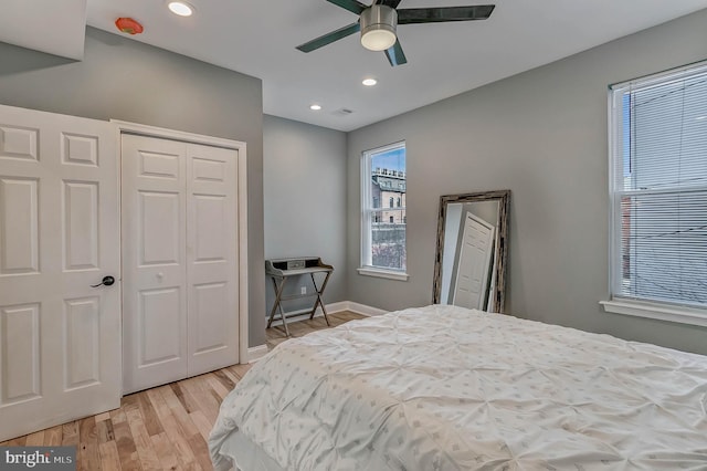 bedroom with ceiling fan, a closet, and light hardwood / wood-style flooring