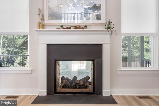 room details with hardwood / wood-style floors and a multi sided fireplace