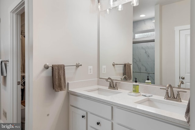 bathroom featuring tiled shower and vanity