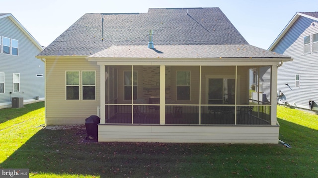 rear view of property featuring a sunroom, a lawn, and central AC unit